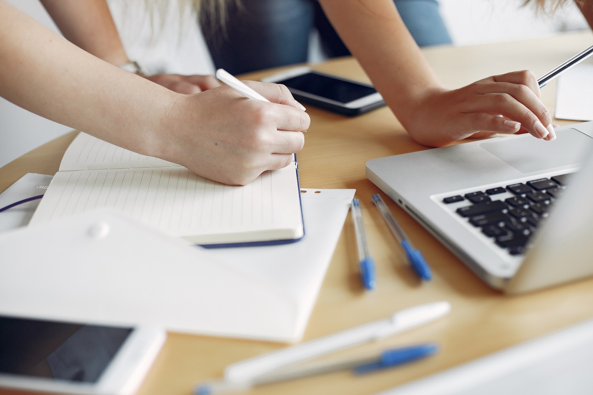 Two Girls In A White T Shirts Working At The Office