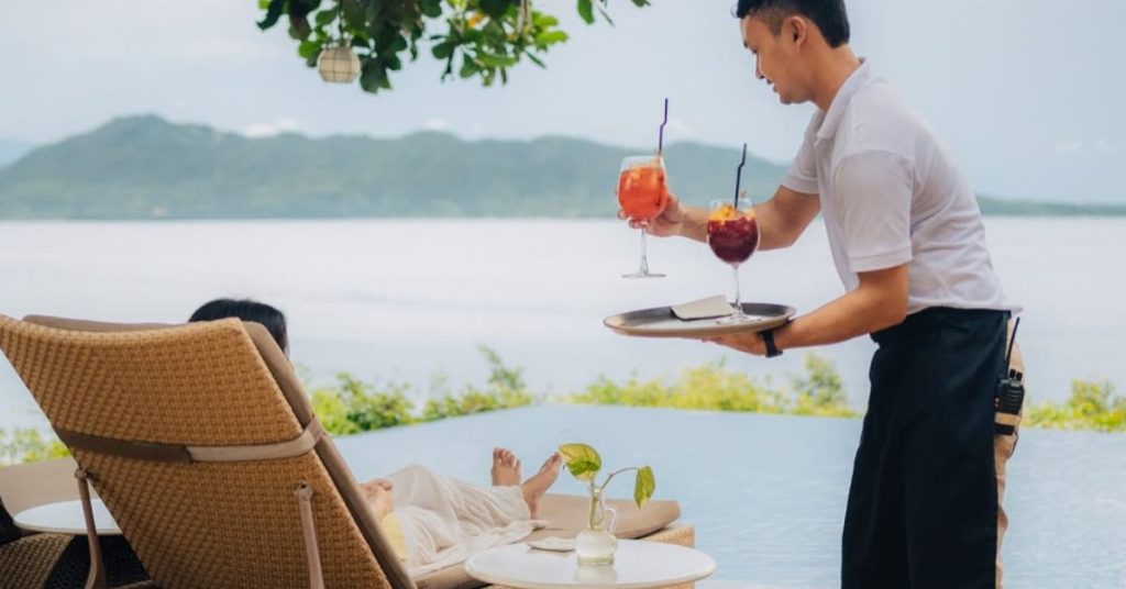 Guests relaxing by the infinity pool overlooking the Batangas coast
